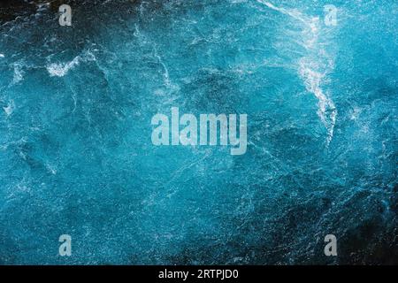 Abstraktes kristallblaues Wasser mit Luftblasen, die von arktischem Hintergrund fließen Stockfoto
