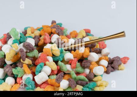 Löffel im Inneren des bunten Cornflake auf weißem Studiohintergrund Nahansicht Stockfoto