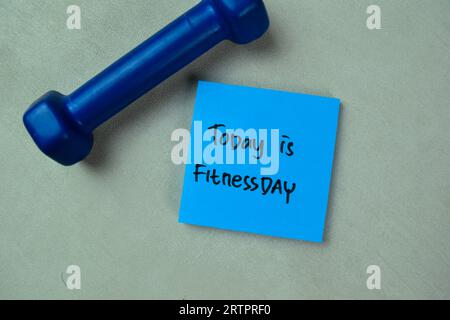 Konzept von heute ist Fitnessday Schreiben Sie auf Haftnotizen isoliert auf Holztisch. Stockfoto
