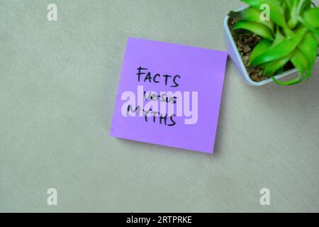 Das Konzept von Fakten versus Mythen schreibt auf Haftnotizen, die auf einem Holztisch isoliert sind. Stockfoto