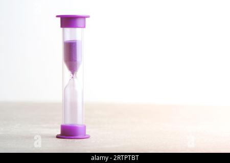 Sanduhr für eine Minute violett auf hellem Hintergrund Stockfoto