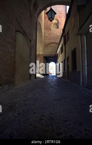 Überdachte Gasse in einem Palast mit Fenstern und Türen an einem sonnigen Tag in einer italienischen Stadt Stockfoto