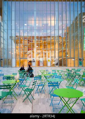 Athen, Griechenland - 10. Februar 2020: Außencafé des Stavros Niarchos Foundation Cultural Center in Kallithea. Straßencafé mit grünen und blauen Tischen Stockfoto