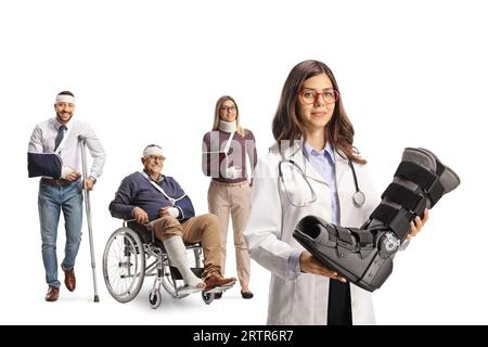 Junge Ärztin, die eine Fußstütze hält und Gruppe von Verletzten, die isoliert auf weißem Hintergrund dahinter stehen Stockfoto