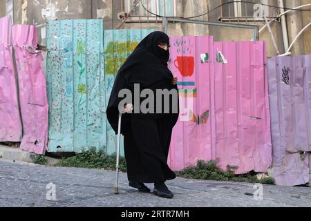 Eine muslimische Frau, die eine Burka trägt, hilft ihr bei ihrem Spaziergang in Istanbul Stockfoto