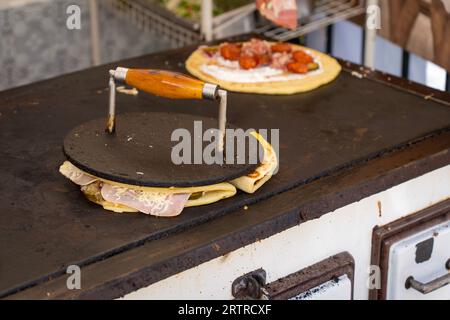 Eine Kuchenform, gebacken unter einer Eisenscheibe auf einem alten Herd im Freien Stockfoto