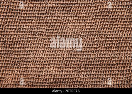 Gewebte natürliche Strohstruktur. Hintergrundstruktur oder Muster aus einem Korb, gewebt mit natürlichem strohfarbenem Schilf. Natürliche Pflanzenfaser Jute Sackleinen. Eco Stockfoto