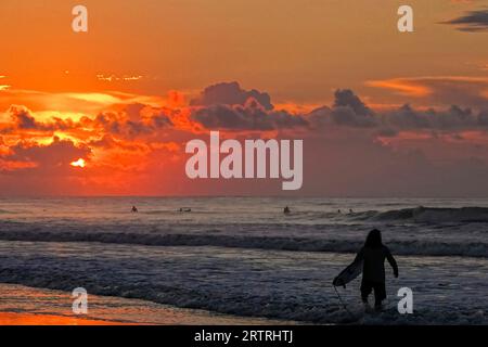 Isle Of Palms, Vereinigte Staaten. September 2023. Surfer, die vom Sonnenaufgang überrascht sind, kommen an, um die größeren Wellen zu nutzen, als der Hurrikan Lee vor der Küste vorbeizieht und starke Surfbedingungen in der Low Country Region bietet, 14. September 2023 in Isle of Palms, South Carolina. Quelle: Richard Ellis/Richard Ellis/Alamy Live News Stockfoto