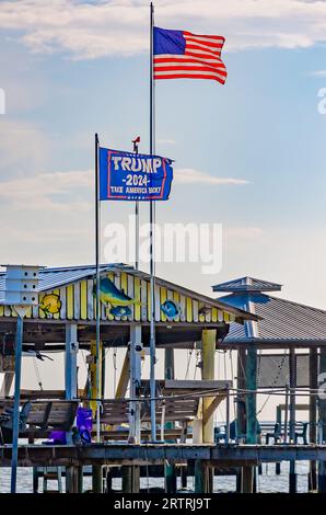 Eine Flagge von Trump 2024 fliegt neben einer amerikanischen Flagge an einem Pier am CODEN Beach, 11. September 2023, in CODEN, Alabama. Stockfoto