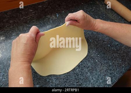 Schwäbische Küche, Zubereitung von deftigem Kartoffelstrudel, Herausziehen von rohem Kartoffelteig, Verarbeitung, Rollnadel, Arbeitsfläche, Herstellung von salzigem Strudel mit Gemüse Stockfoto