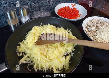 Schwäbische Küche, Zubereitung von deftigem Kartoffelstrudel, Braten von geriebenen und gekochten Kartoffeln, Herstellung der Füllung, Gemüse, salziger Strudel mit Gemüse Stockfoto