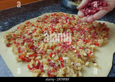 Schwäbische Küche, Zubereitung von deftigem Kartoffelstrudel, roher Kartoffelteig mit Gemüse, dazu Speckwürfel, geräuchertes Fleisch, Verarbeitung, geröstet Stockfoto