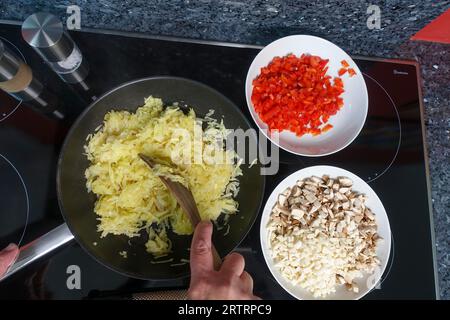 Schwäbische Küche, Zubereitung von deftigem Kartoffelstrudel, Braten von geriebenen und gekochten Kartoffeln, Herstellung der Füllung, Gemüse, salziger Strudel mit Gemüse Stockfoto