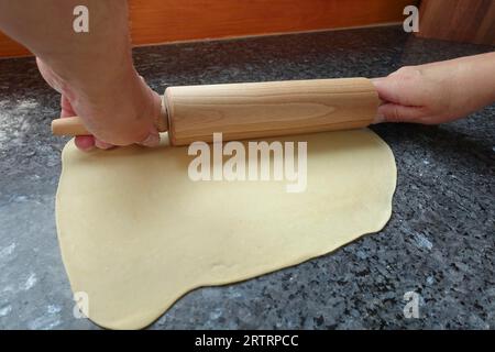 Schwäbische Küche, deftiger Kartoffelstrudel zubereiten, rohen Kartoffelteig ausrollen, Verarbeitung, Rollnadel, Arbeitsfläche, Salzstrudel mit Gemüse zubereiten Stockfoto