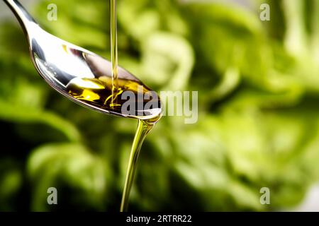 Olivenöl fließt über einen Löffel Stockfoto