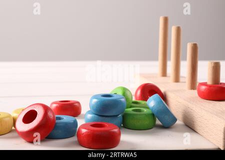 Entwicklung motorischer Fähigkeiten. Stapeln und Zählen von Spielsteinen auf weißem Tisch Stockfoto