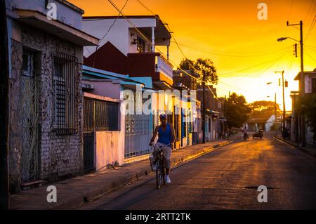 Camagüey, Kuba am 2. Januar 2016: kubanische Mann mit seinem Fahrrad durch eine Straße in der Karibik Altstadt Zentrum von Camagüey bei Sonnenuntergang Stockfoto