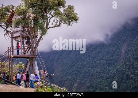 Banos, Ecuador am 18. November 2015: Touristen genießen die Riesenschaukel im Baumhaus Casa del Arbol in den Anden bei Banos, Ecuador. Die Aussicht Stockfoto