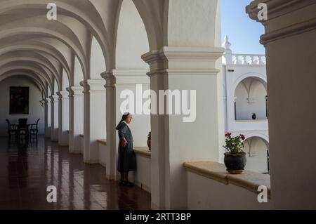 Sucre, Bolivien im September 2015: Eine Nonne schaut aus einem Fenster in einem Kloster. Das Kloster ist ein wunderschönes Kolonialgebäude in Bolivias Hauptstadt Stockfoto