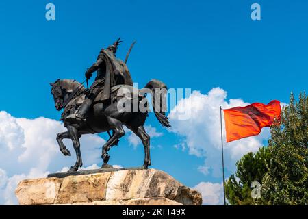 Skanderbeg-Pferdedenkmal am Skanderbeg-Platz in Tirana und die rote Flagge Albaniens Stockfoto