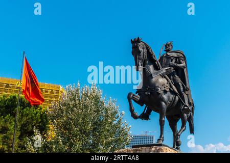 Das wunderschöne Skanderbeg-Pferdedenkmal auf dem Skanderbeg-Platz in Tirana und die rote Flagge Albaniens Stockfoto