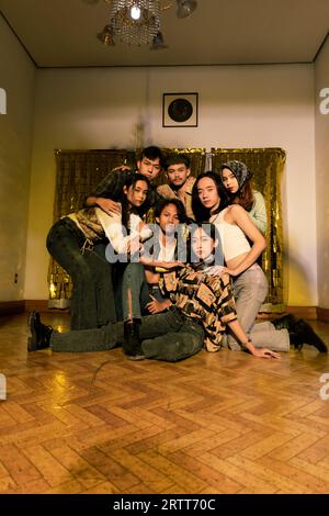 Eine Gruppe asiatischer Leute, die mit ihren Freunden in einem alten Zimmer abhängen, während sie nachts zusammen im Urlaub sind Stockfoto