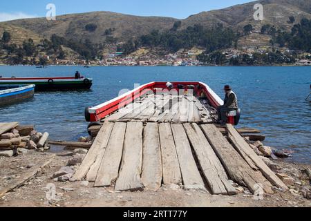 Tiquina, Bolivien, 22. Oktober 2015: Mann sitzt auf einer hölzernen Fähre am Titicacasee Stockfoto