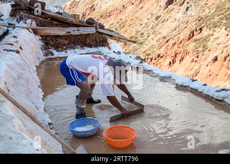 Maras, Peru, 11. Oktober 2015: Man arbeitet in einem Salzverdampfungspeich in den Salzminen von Maras Stockfoto