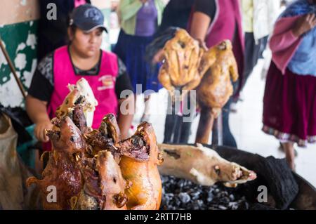 Cuenca, Ecuador am 15. November 2015: Frau vom Grill BBQ Meerschweinchen auf dem Markt verkaufen. Eine örtliche Delikatesse, die Nager werden gehäutet und Stockfoto