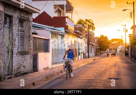 Camagüey, Kuba am 2. Januar 2016: kubanische Mann mit seinem Fahrrad durch eine Straße in der Karibik Altstadt Zentrum von Camagüey bei Sonnenuntergang Stockfoto