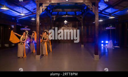 Eine Gruppe javanischer Tänzer tanzt nachts in einem Pavillon mit braunem Holz Stockfoto