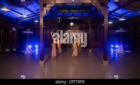 Eine Gruppe javanischer Tänzer tanzt nachts in einem Pavillon mit braunem Holz Stockfoto