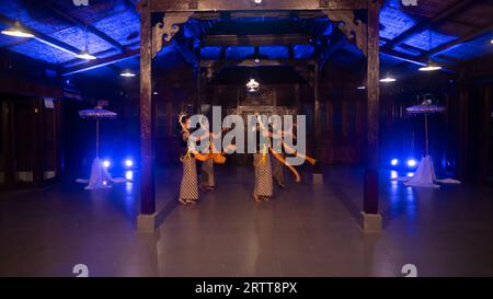 Eine Gruppe javanischer Tänzer tanzt nachts in einem Pavillon mit braunem Holz Stockfoto