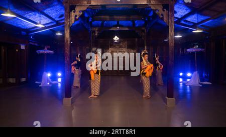 Eine Gruppe javanischer Tänzer tanzt nachts in einem Pavillon mit braunem Holz Stockfoto