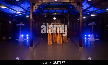 Eine Gruppe javanischer Tänzer tanzt nachts in einem Pavillon mit braunem Holz Stockfoto