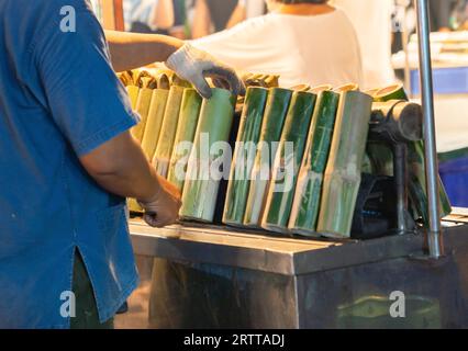 Der Mann grillt glutenfreien Reis, der auf dem Straßenmarkt geröstet wird. Stockfoto