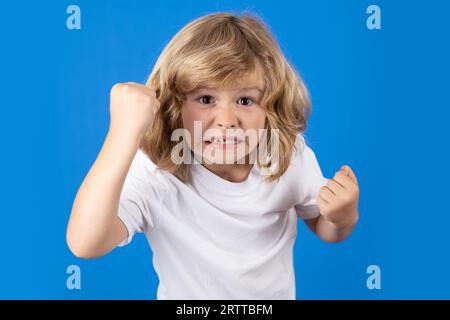 Kind mit wütendem Ausdruck im Studio. Wütender, hasserfüllter kleiner Junge, wütendes Kind. Wütende Wut, die Kinder sehen. Wütendes Kind mit wütender negativer Emotion Stockfoto