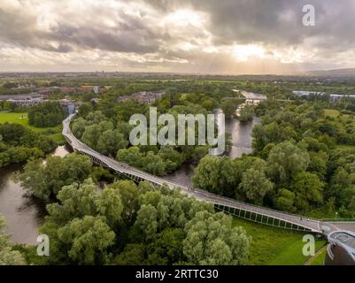 Panoramablick auf die Living Bridge, kurvenreiche moderne Fußgängerüberquerung über den Shannon River an der Universität von Limerick mit atemberaubendem Sonnenuntergang Stockfoto