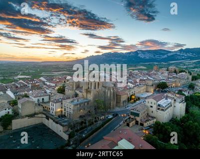 Blick aus der Vogelperspektive auf Laguardia mittelalterliches befestigtes Dorf auf einem Hügel, umgeben von Weingütern in der spanischen Region Rioja, mit farbenfrohem Sonnenuntergang Stockfoto