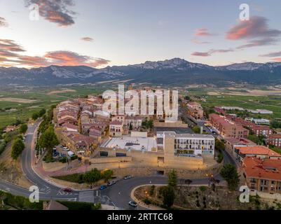 Blick aus der Vogelperspektive auf Laguardia mittelalterliches befestigtes Dorf auf einem Hügel, umgeben von Weingütern in der spanischen Region Rioja, mit farbenfrohem Sonnenuntergang Stockfoto