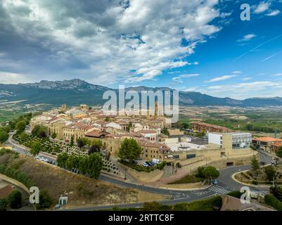 Blick aus der Vogelperspektive auf Laguardia mittelalterliches befestigtes Dorf auf einem Hügel, umgeben von Weingütern in der spanischen Region Rioja, mit bewölktem Himmel Stockfoto