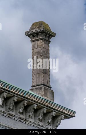 Blick aus nächster Nähe auf den hohen traditionellen klassischen Steinkamin auf einem Dach Stockfoto