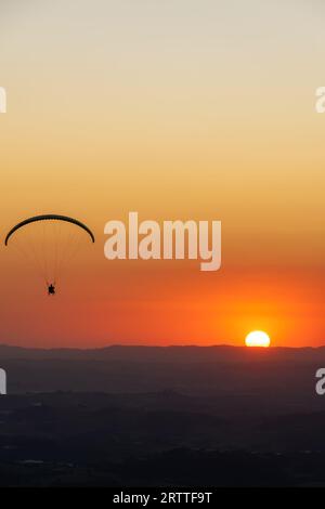 Gleitschirmfliegen bei Sonnenuntergang. Pedra Grande, in Atibaia, Brasilien Stockfoto