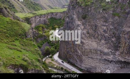 Eine Panoramastraße durch eine enge Schlucht, gesäumt von üppigem Grün auf beiden Seiten Stockfoto
