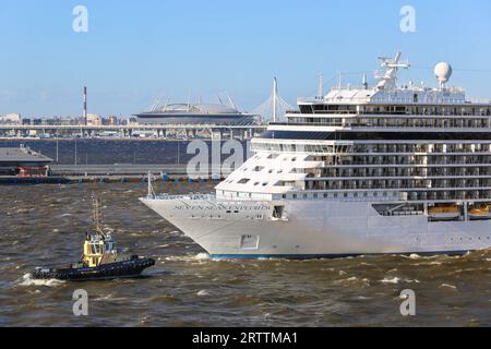 Regent Cruises Luxus-Kreuzfahrtschiff Seven Seas Explorer verlässt St. Petersburg Kreuzfahrtterminal Nr. 1 und Krestowsky Gazprom Stadium, Russland, Schlepper Stockfoto