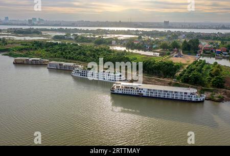 Mekong River aus der Vogelperspektive: Kreuzfahrtschiffe Amalotus, Scenic Spirit, Mekong Prestige 1 & 2 am Ufer, Phnom Penh & Tonle SAP River Hintergrund Stockfoto