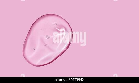 Serum-Gel-Farbfeld auf rosafarbenem Hintergrund. Kosmetische, transparente Gel-Serum-Textur. Stockfoto
