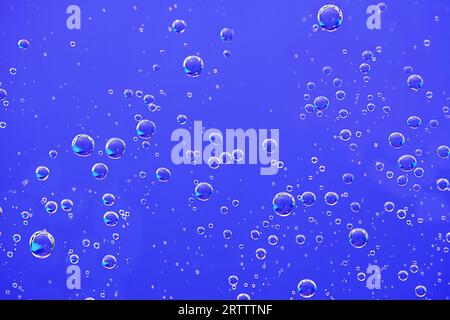 Hintergrund mit Wasserblasen. Makrosauerstoffblasen in Wasser auf blauem Hintergrund. Stockfoto