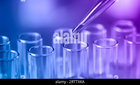 Reagenzgläser mit blauen Flüssigwasserproben und Pipette. Pipettieren Sie die Probe in das Reagenzglas. Laborglaswaren, wissenschaftliche Laborforschung Conce Stockfoto