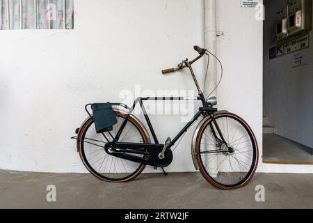 Städtisches Detail eines Fahrrads ohne Sattel, der an einer Wand anliegt, im Tiong Bahru Estate, Singapur Stockfoto